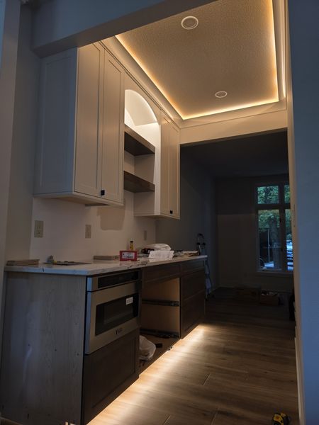 Kitchenette with LED cove lighting in the ceiling and toe-kick lighting under the cabinets