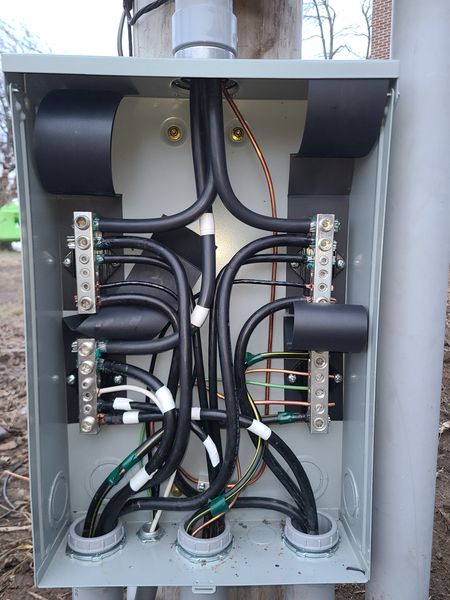 Inside a meter base enclosure showing service conductor terminations