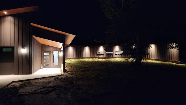 Modern home exterior at night with soffit lighting