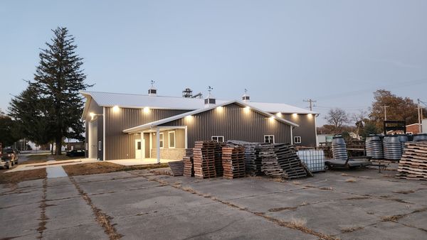 Steel shop building at dusk with exterior wall lights