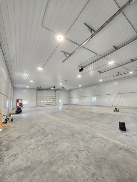 Large shop interior with round LED ceiling lights and an overhead door